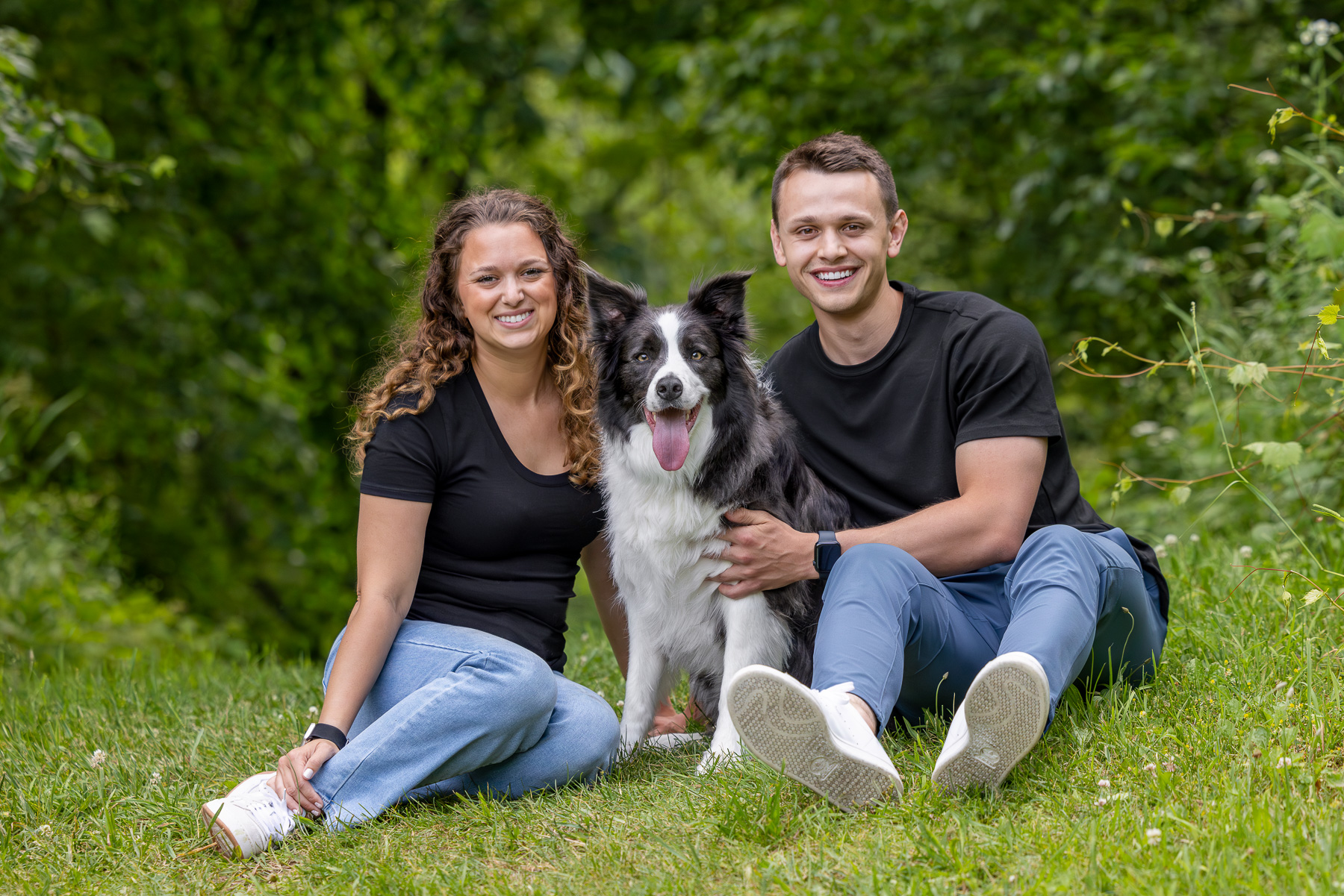 A young family of three pose on a hill at Prairie Wolf Park in Caledonia, MI.