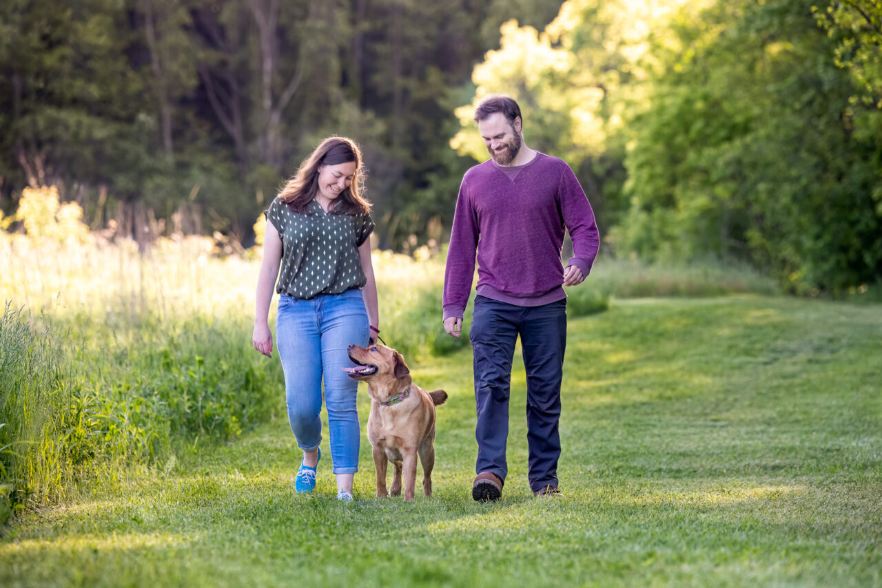 A man and a woman walk with their red Retriever at Prairie Wolf park in Caledonia, MI.